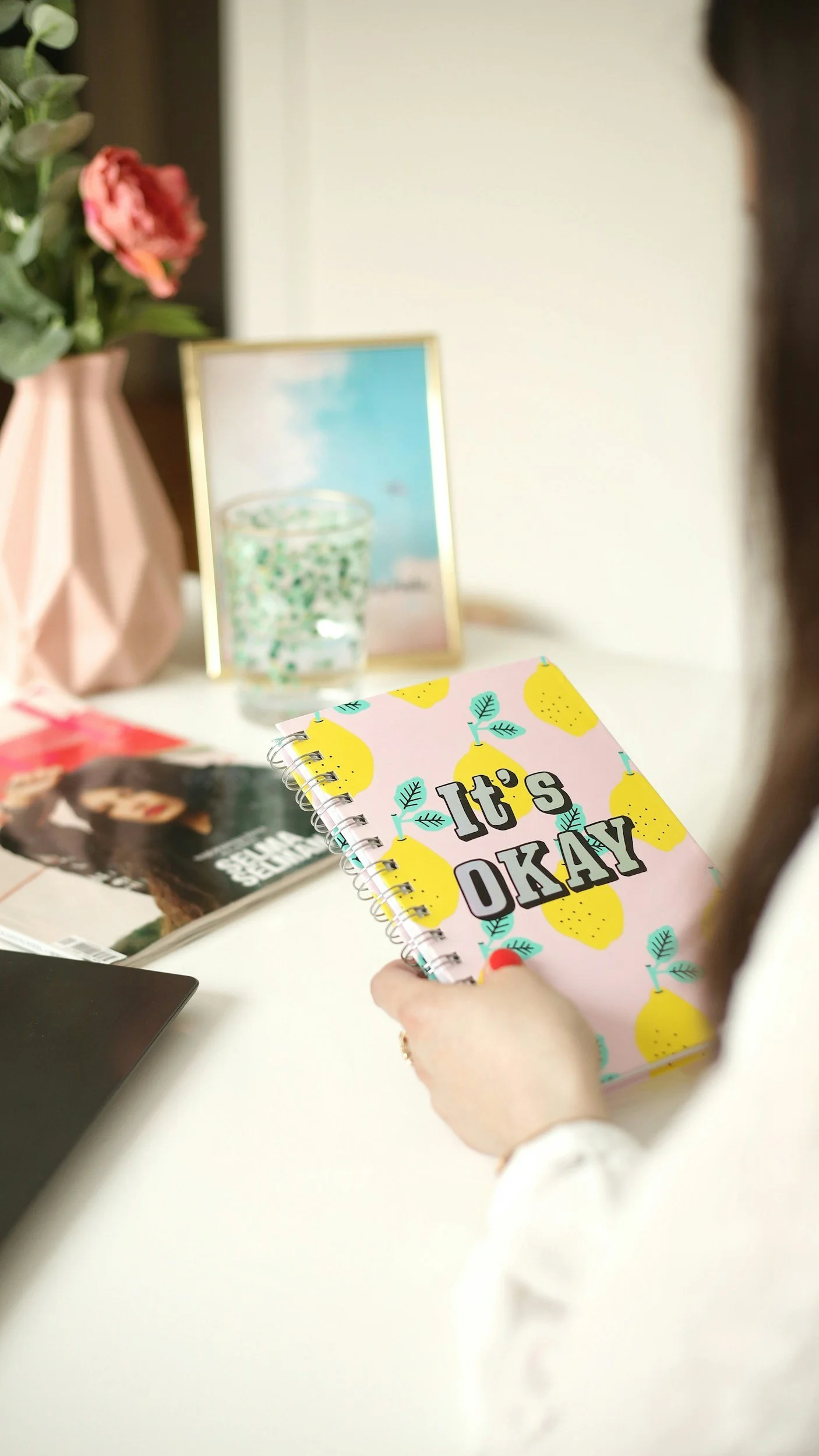 Tween girl holding journal that says "it's okay"