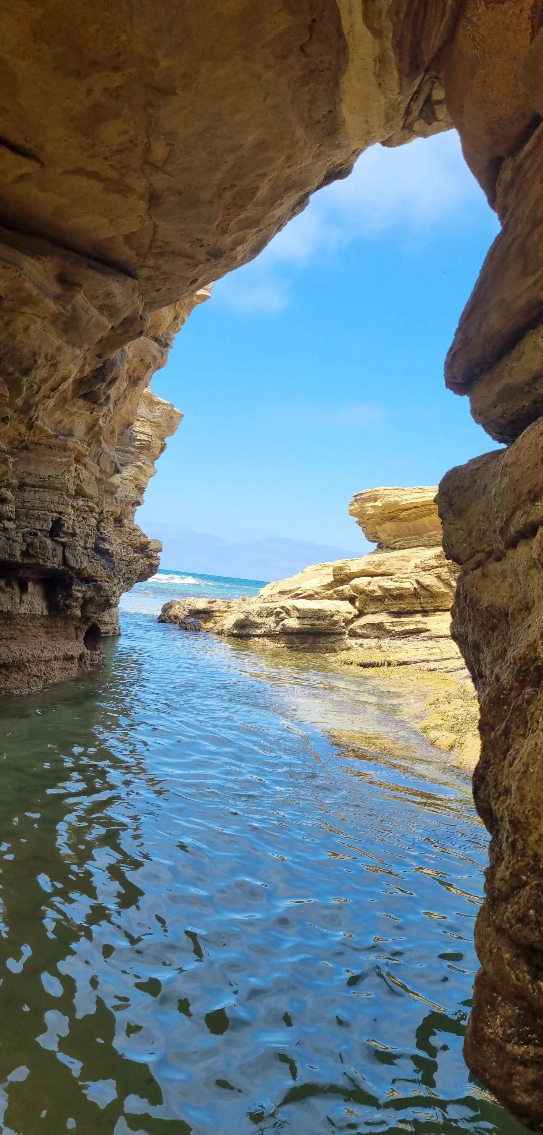 Rock formations and clear ocean water at Sunnymead Beach, creating a calm and grounding setting.