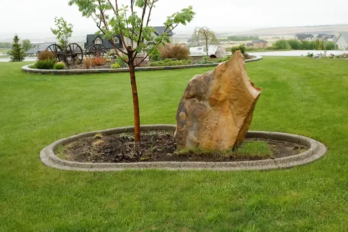 Custom exposed aggregate concrete edging around flower beds
