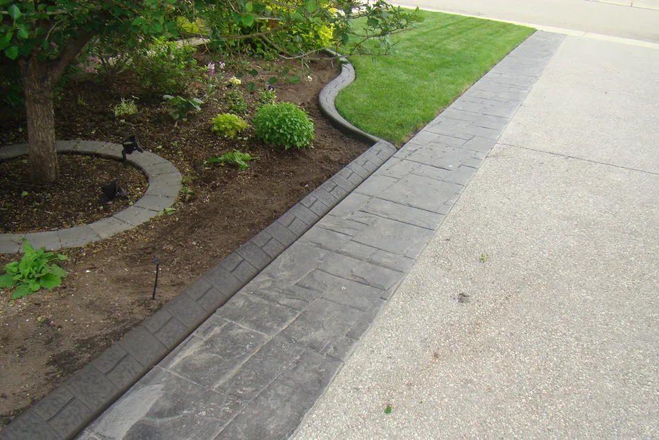 Stamped concrete borders creating clean lines around garden beds and driveway