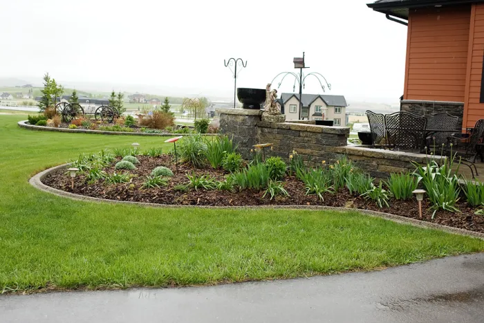 Exposed aggregate curbing framing garden beds in rural front yard