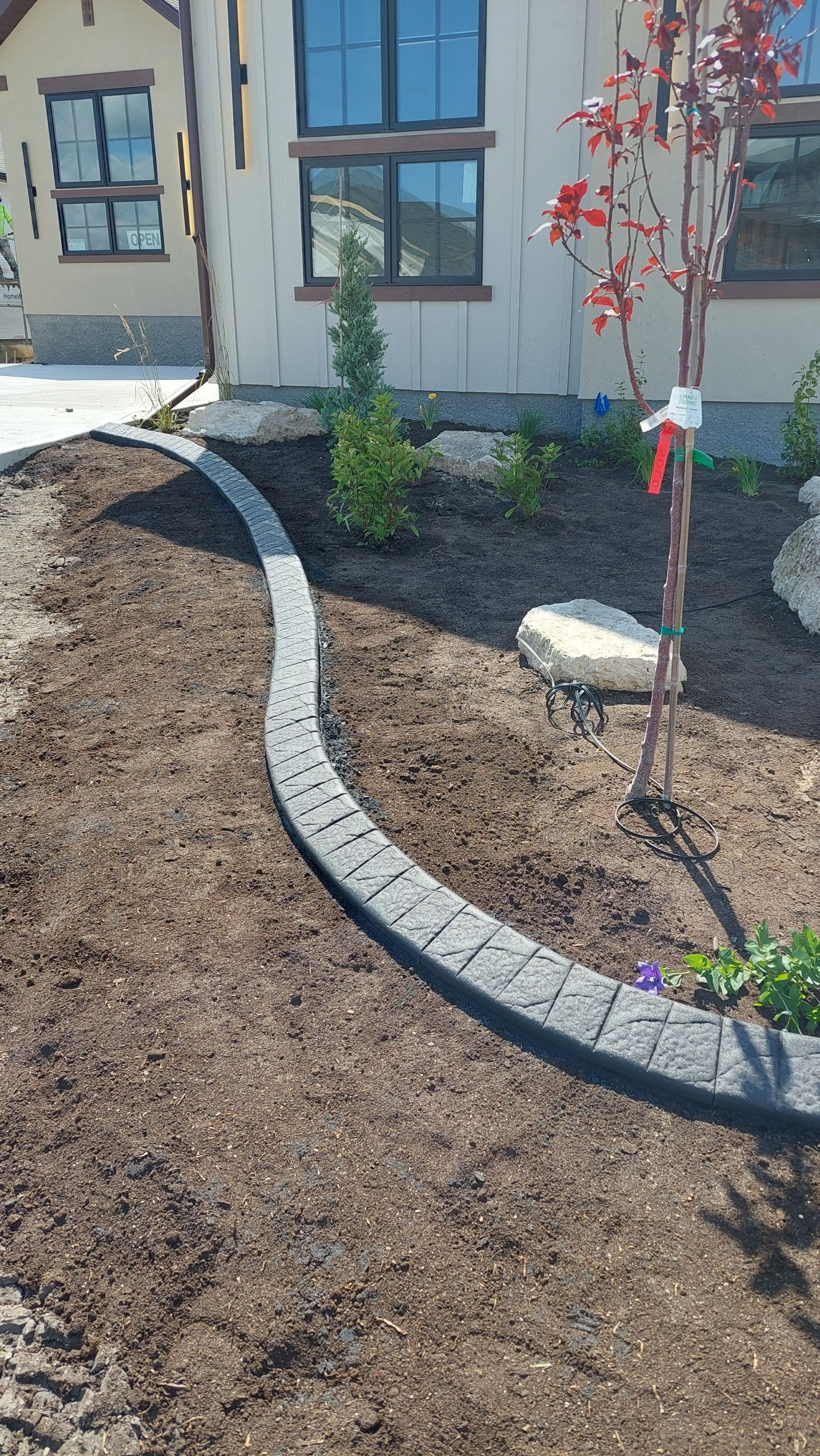 Textured concrete curbing with custom profile in High River before lawn gets laid