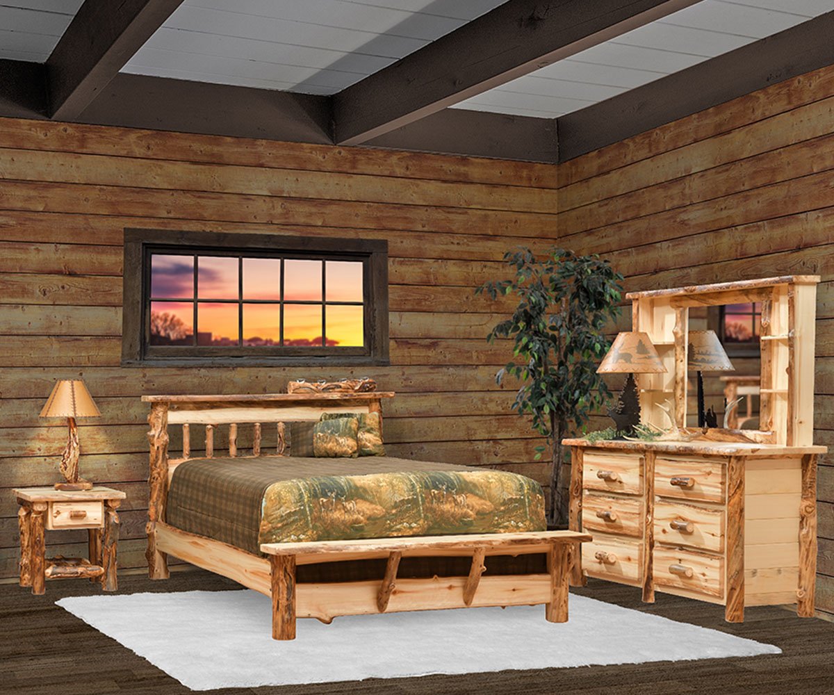 A rustic bedroom with wooden walls, a window showing a sunset, a wooden bed with camouflage bedding, nightstand with lamp, and a dresser with mirror and lamp, a large potted plant, and a white rug on dark hardwood floor.
