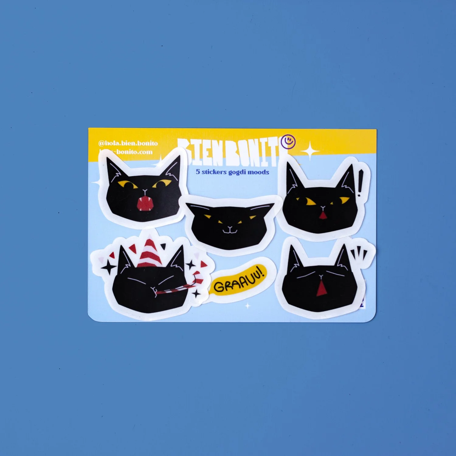 Pequeña caja de cera de color rosa con imágenes de gatos negros en el exterior y logotipo en la parte superior.