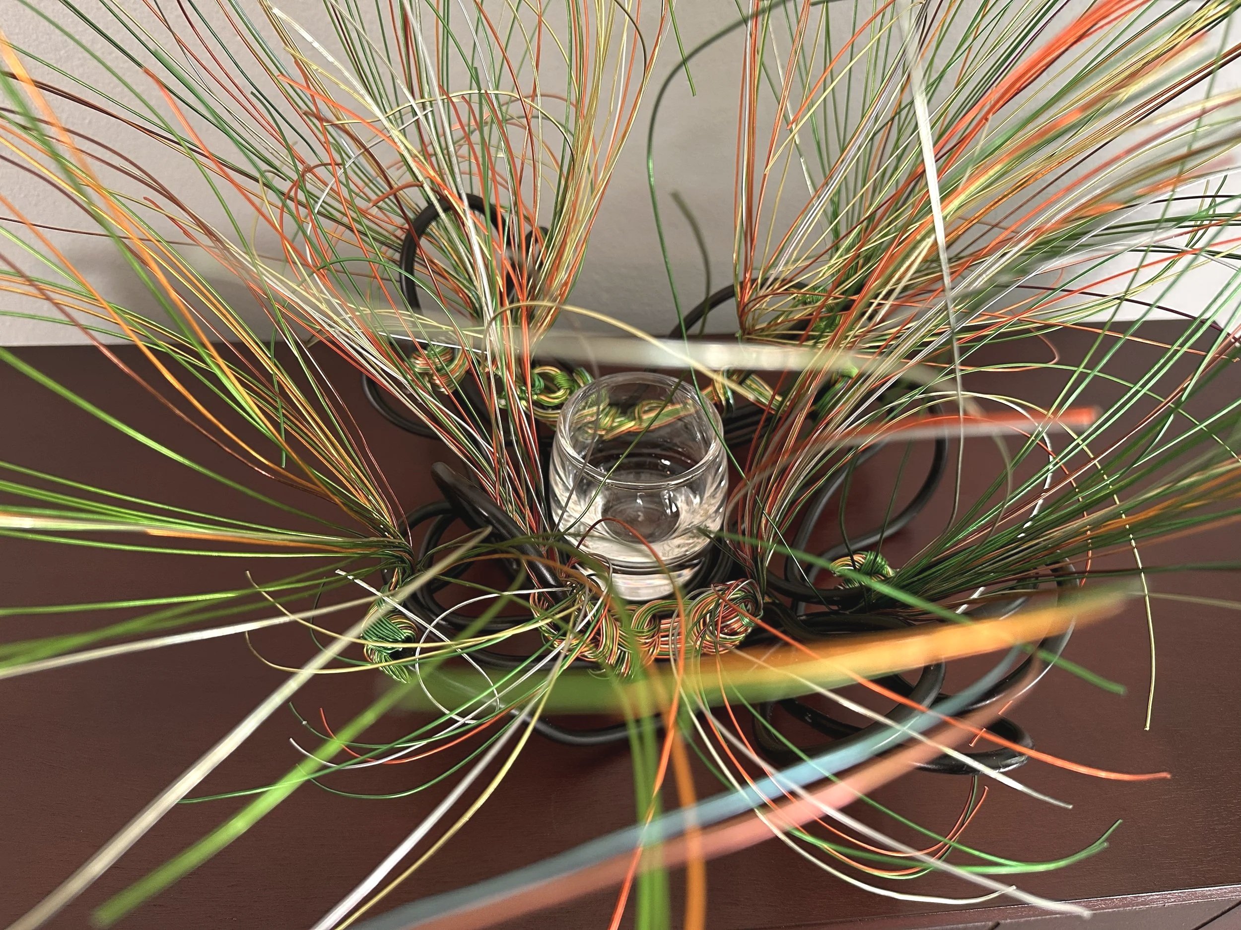 Title: "Swaying" Aerial.   
Dimension: 1. 1' 6" × 1' 6" × 1' 6"
Wires rise in a gentle flare, as if catching the first hint of a breeze. A compact form with a quiet upward motion, holding the soft lift of something just beginning to open.



Hand‑for