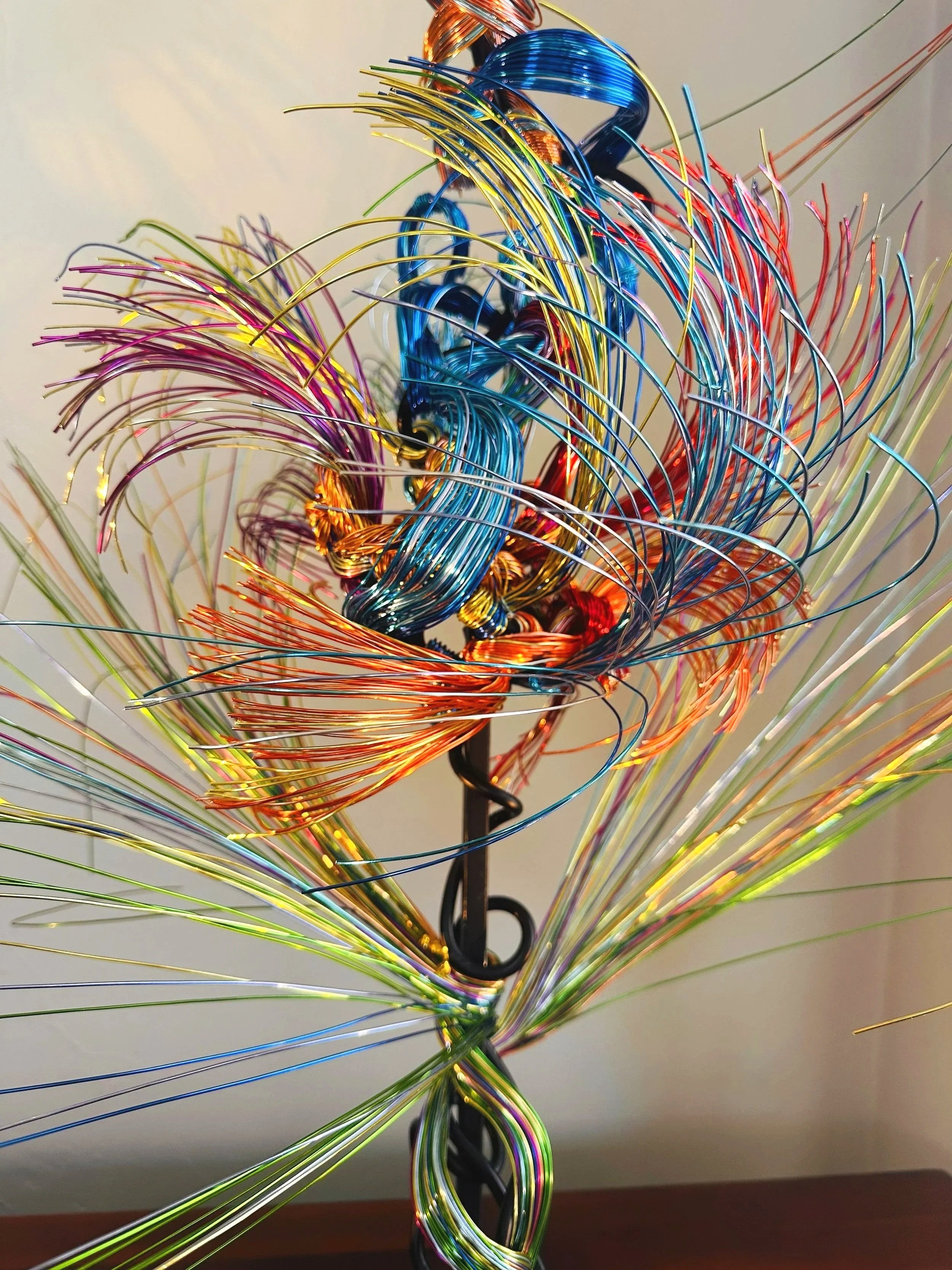 Title: Aglow in Motion. Center View. Detail #1  
Dimension. 2" x 2" x 4".8' 
This center view of the piece explores the soft resilience of floral forms — branches lifting, colors gathering, and thin lines swaying as if touched by light. Shaped slowly