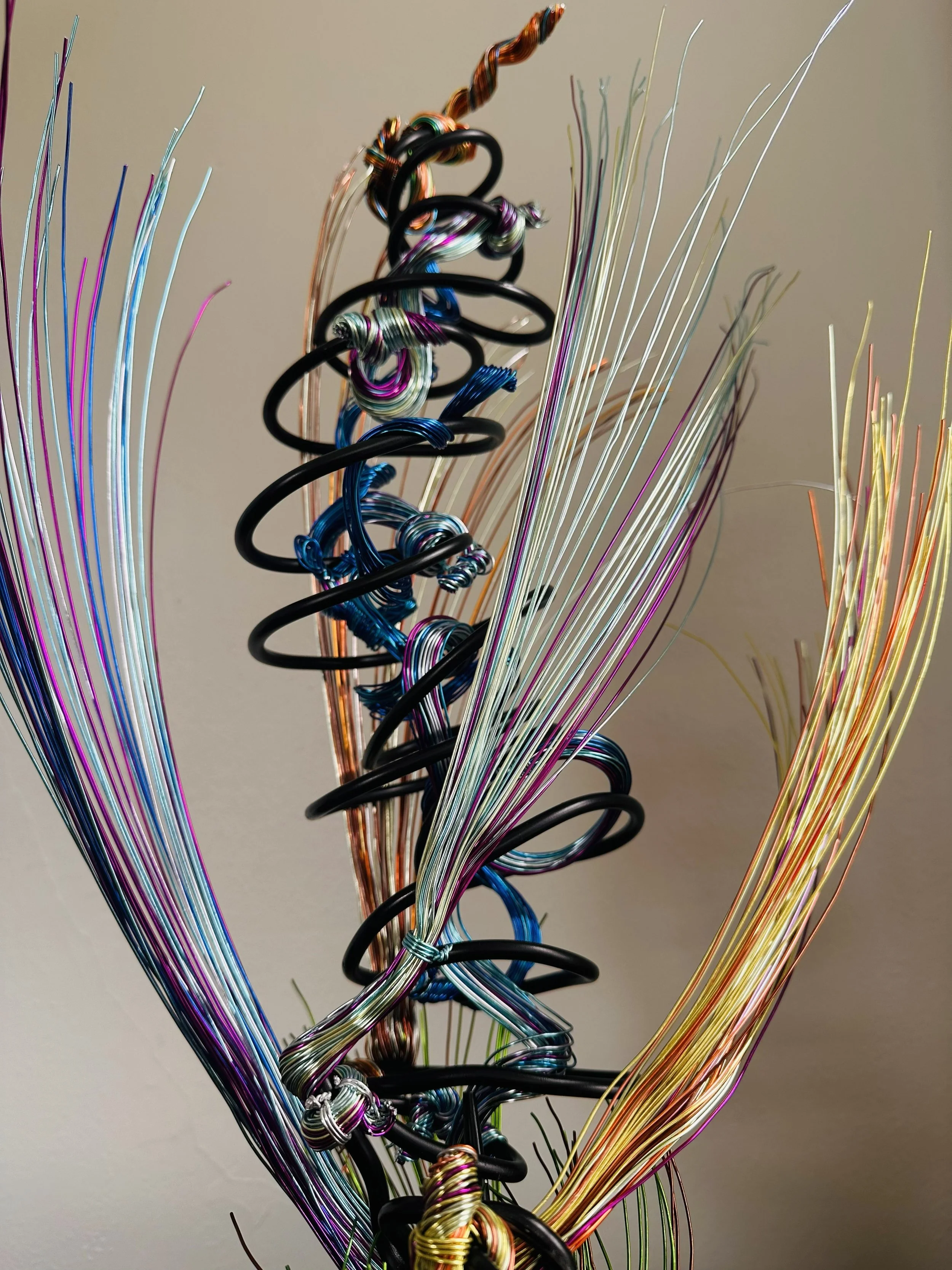 Title: "Rising"" View from front.
Dimensions:   1' 6" × 1' 6" × 2' 5"
The form stretches upward, its strands leaning into imagined air. A sculpture that feels mid‑movement — rooted below, reaching toward whatever shift is happening above.