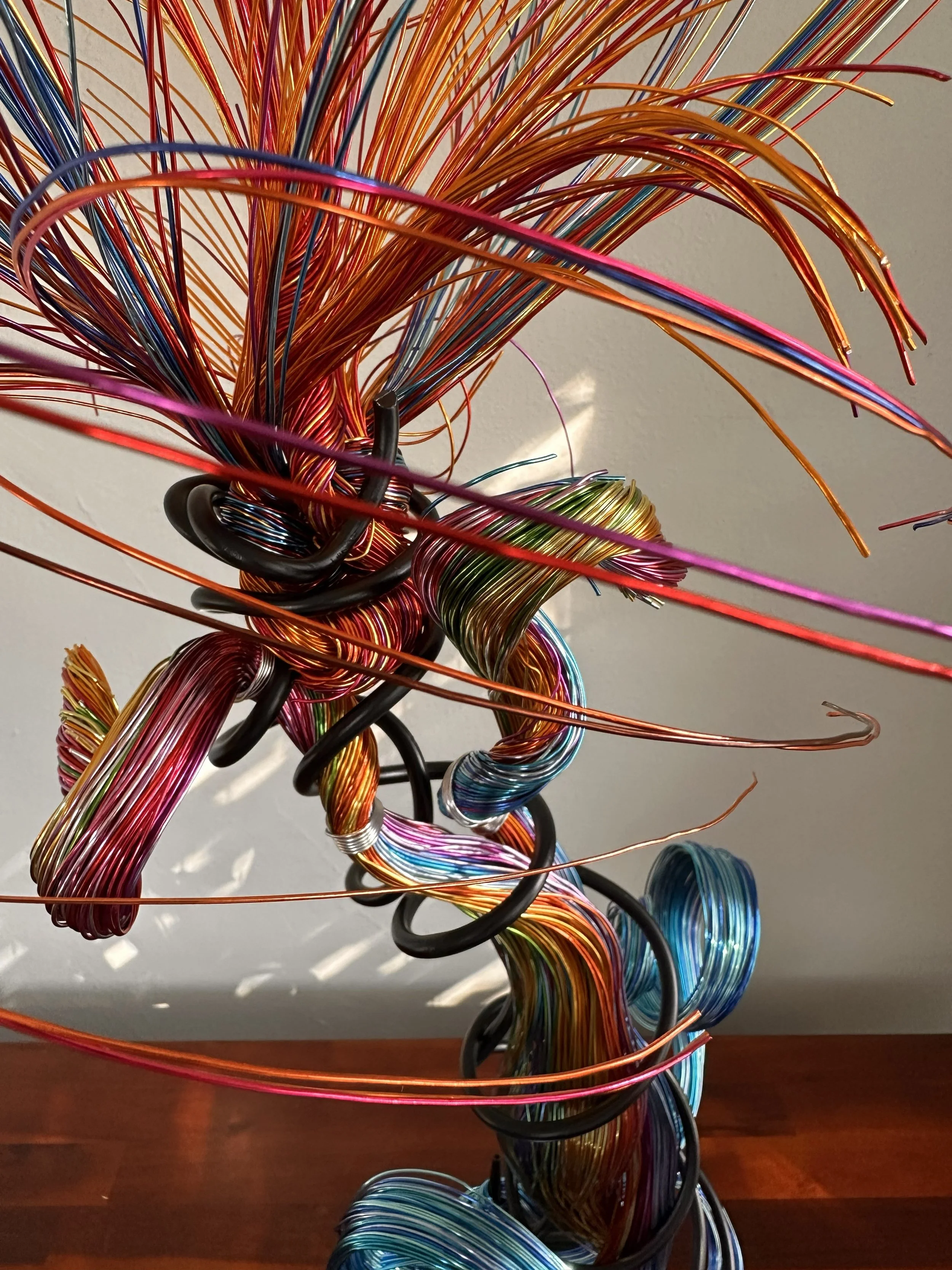Title: "Flowing" 
Dimensions:  1' 8" × 1' 8" × 3' 0"
A red flare rises through volcanic heat, branching into color before opening into a glowing, palm‑like burst.
