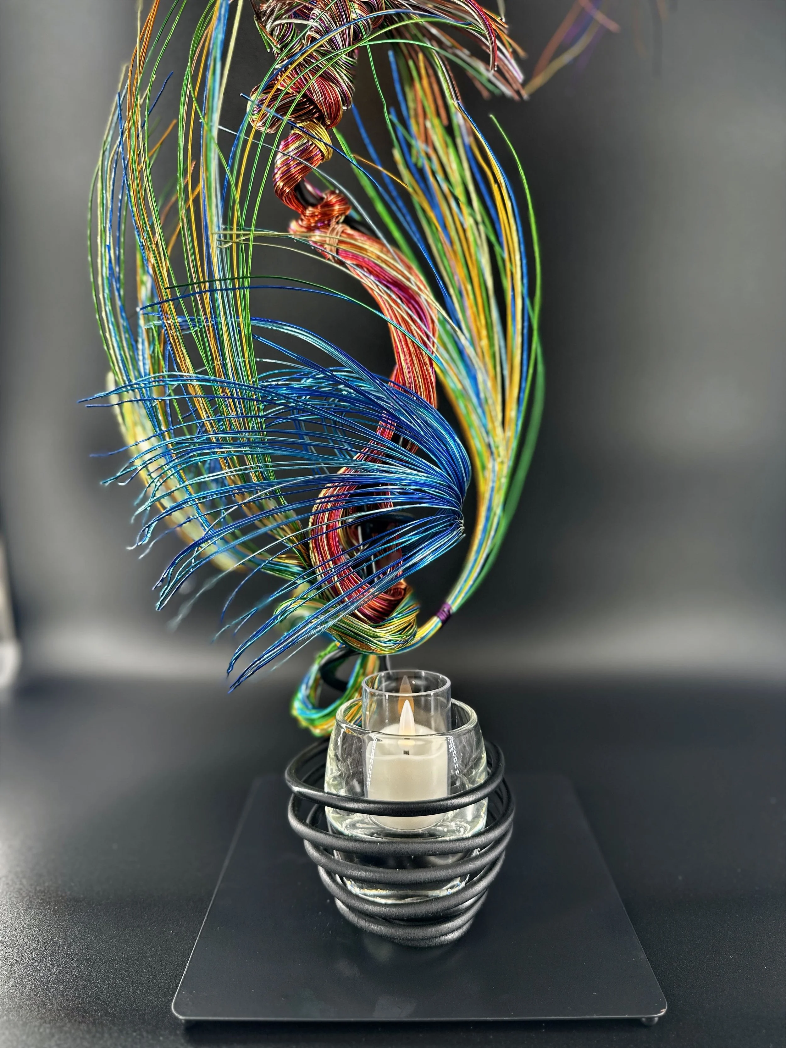 A slender vertical lift, the wires rising in a narrow column before drifting outward. It feels like a thin current of air carrying something upward.
