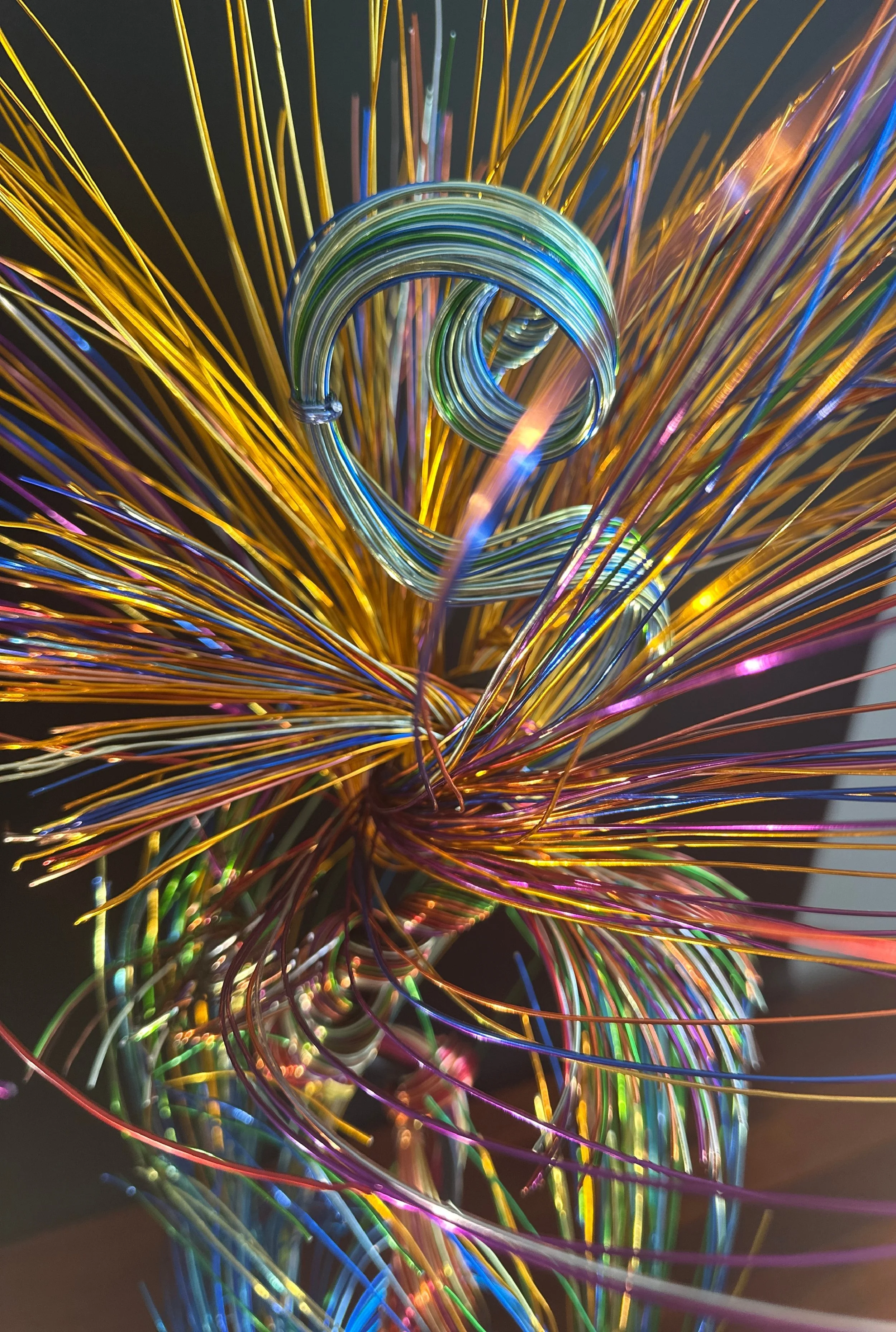 A slender vertical lift, the wires rising in a narrow column before drifting outward. It feels like a thin current of air carrying something upward.