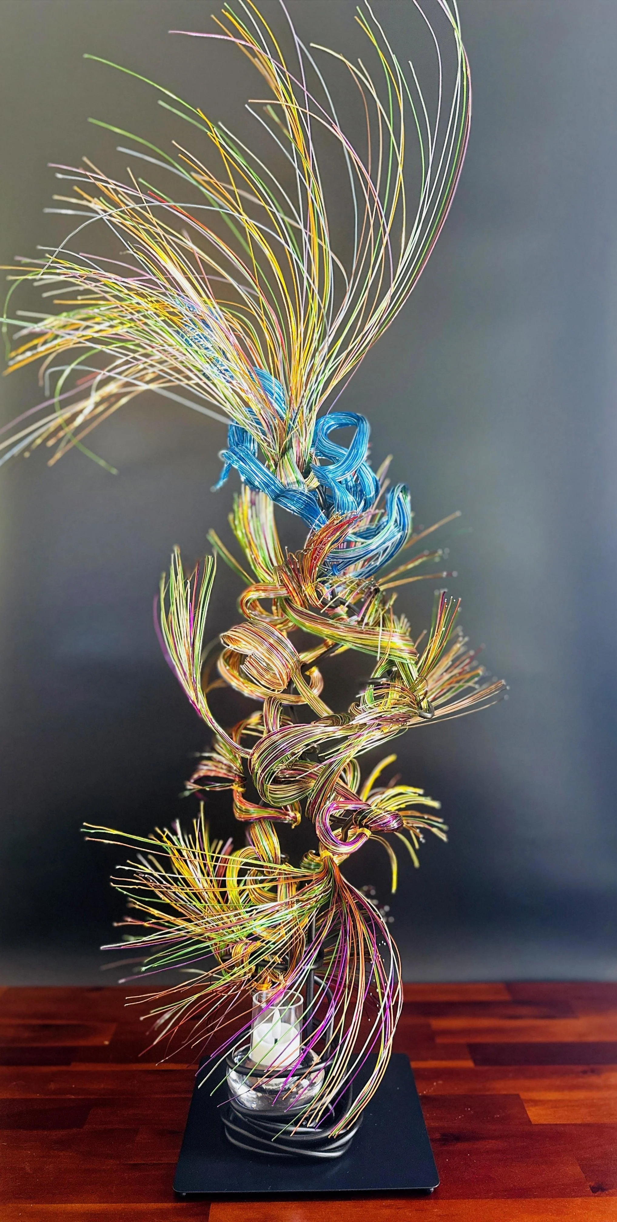 Branches intertwine and rise together, a flowing current of earth and water — separate forms gathering into one luminous motion.