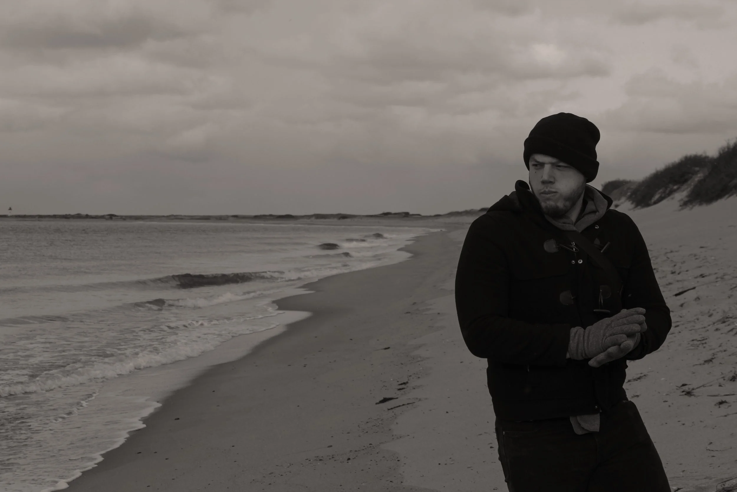Man walks along beach in winter
