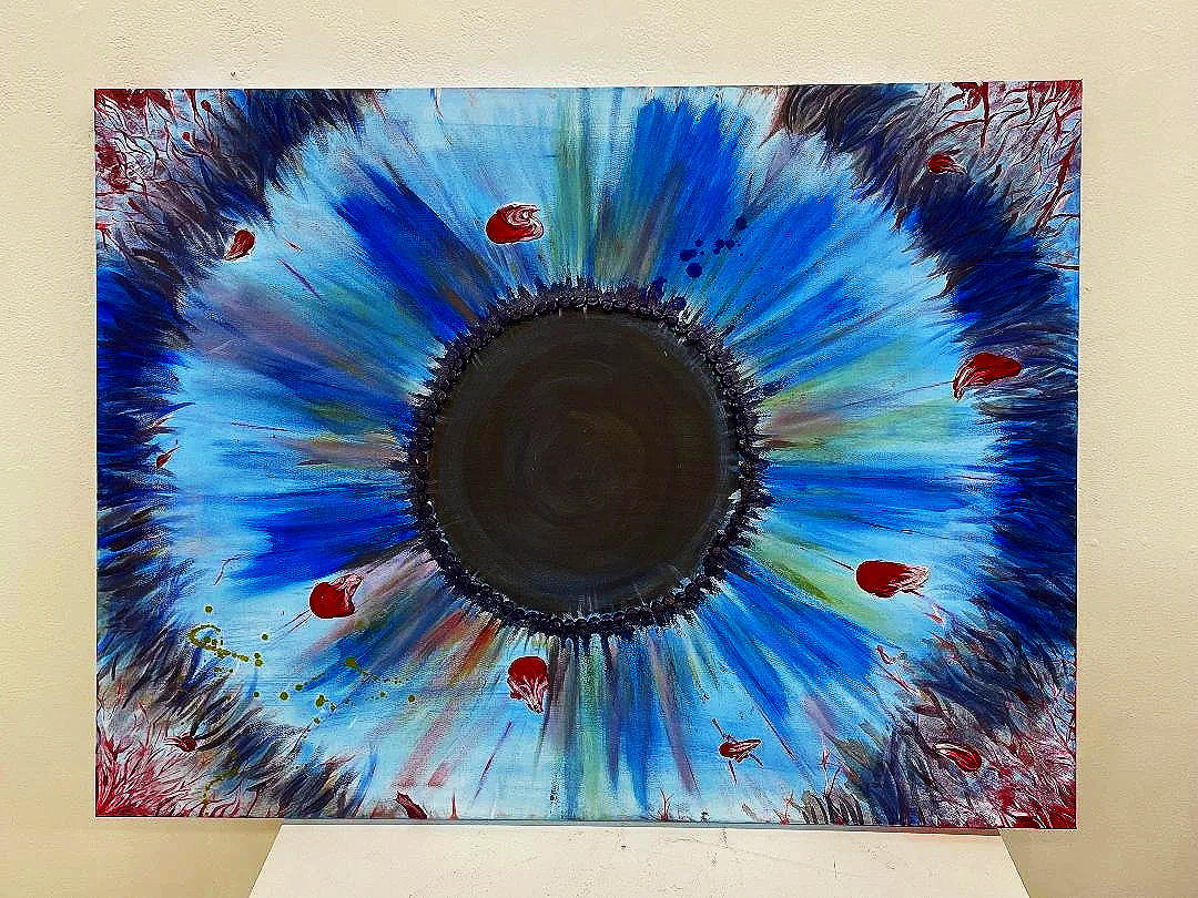 Abstract painting resembling a large eye with a black circular center, surrounded by blue, green, red, and black streaks and splatters, on a white background.