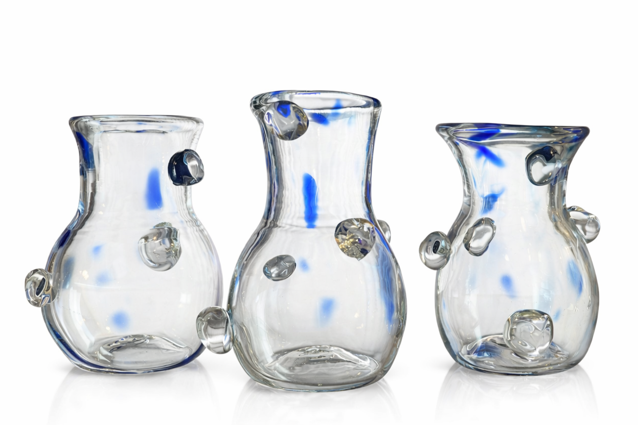 Three clear glass vases with blue accents and decorative bubbles inside, positioned in a row against a white background.
