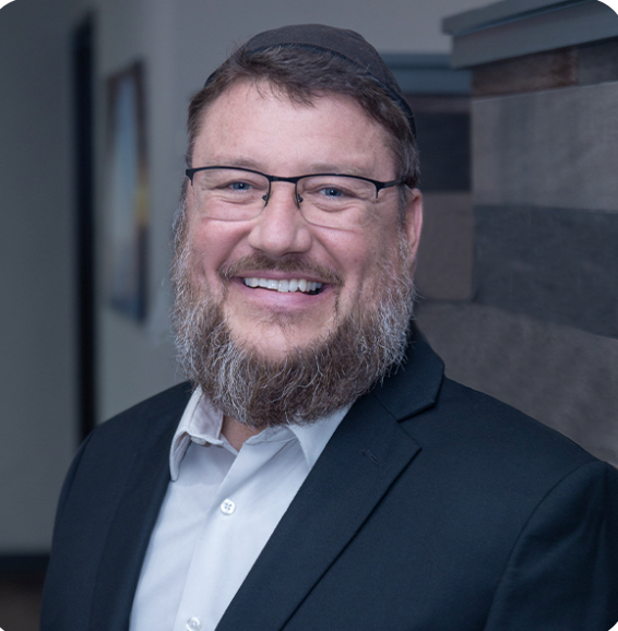 Robert Bauer, Board Certified Nurse Practitioner certified in Functional Medicine wearing a suit jacket and white shirt, standing indoors against a blurred background.