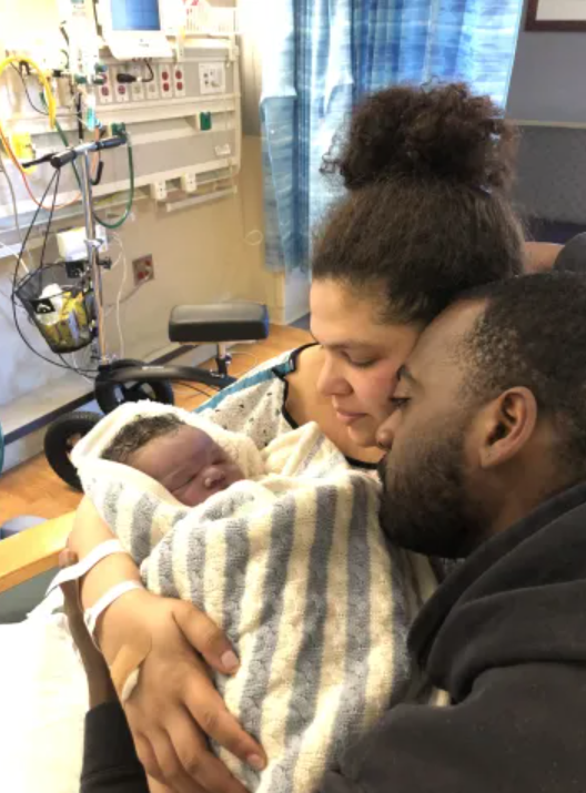 Parents holding their newborn baby in a hospital room, symbolizing neonatal care, family support, and love.