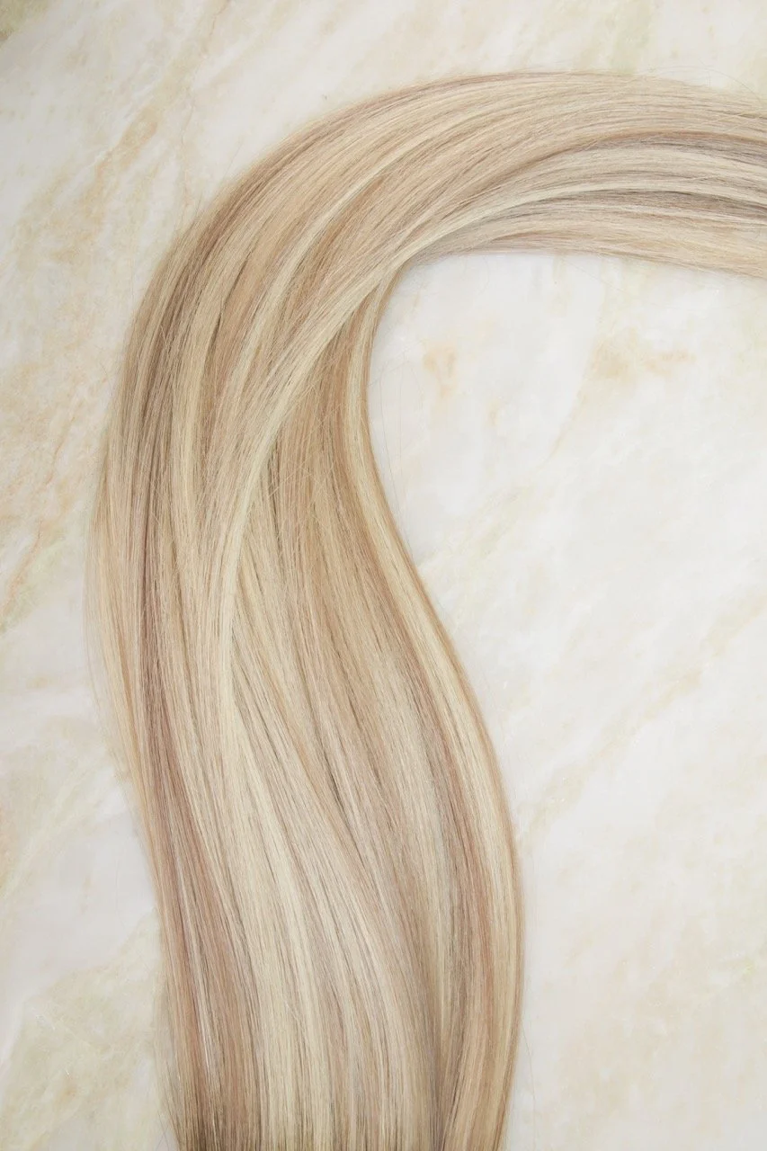 Strands of blonde hair on a marble-like surface