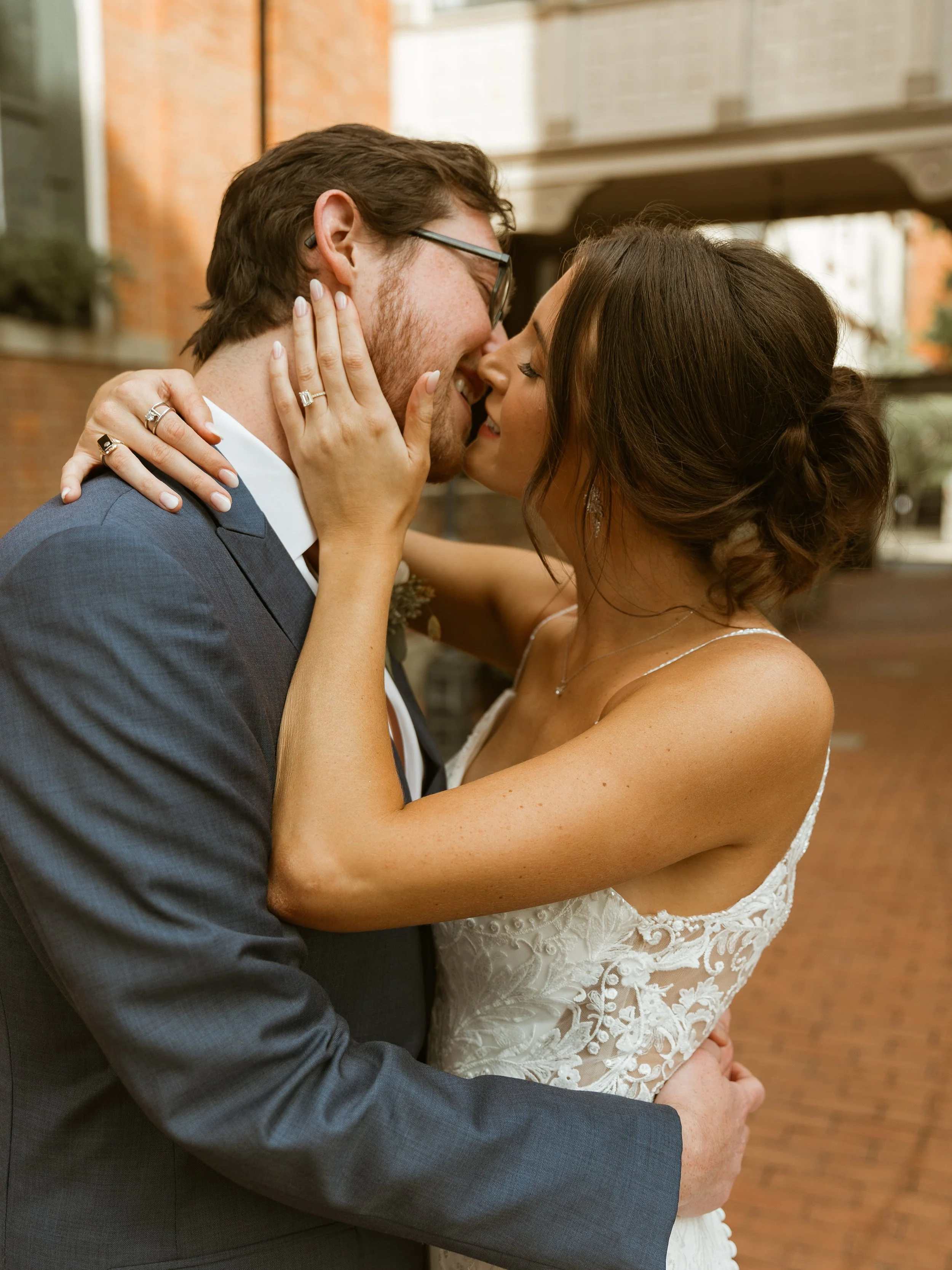 A newlywed couple kissing and embracing outdoors.