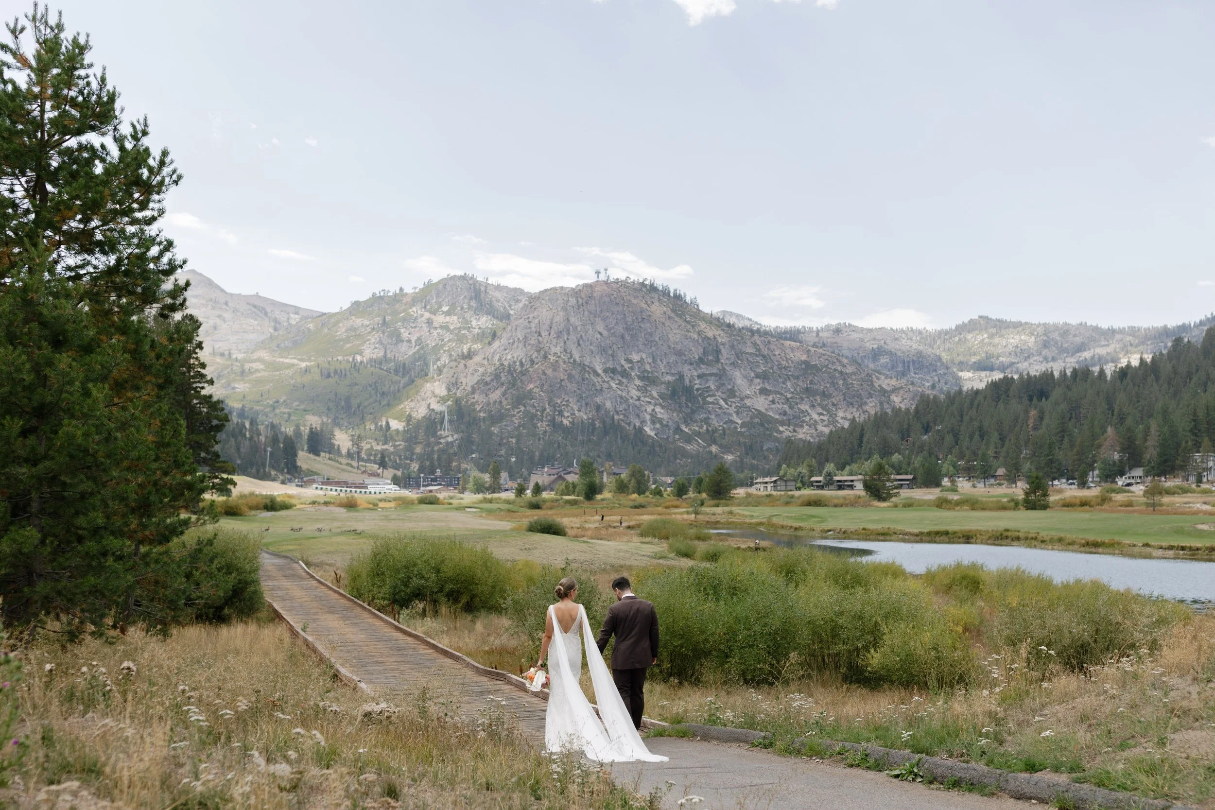 Everline Resort Lake Tahoe wedding with mountain views, couple walking along a scenic outdoor path.