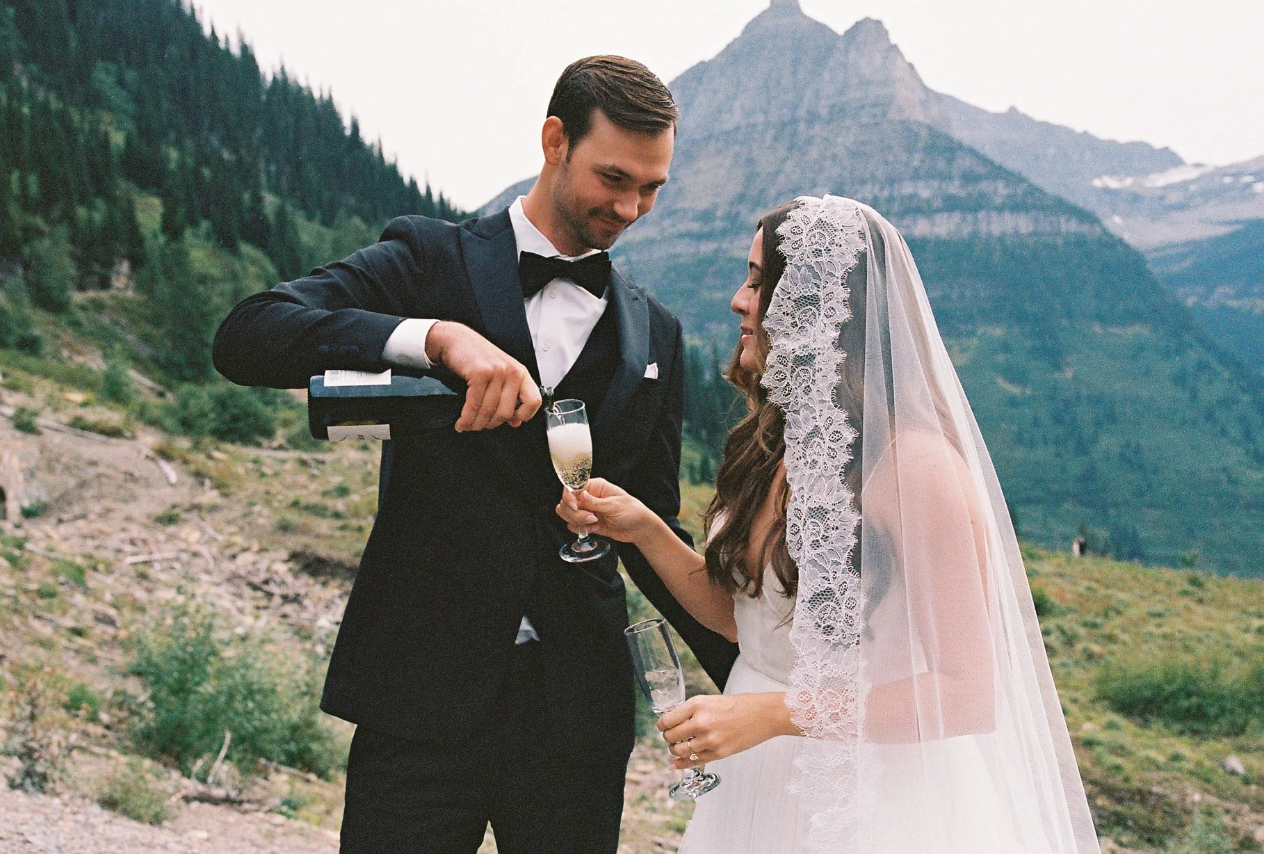 Lake Tahoe mountain wedding with bride in a Chantilly lace mantilla veil, candid champagne toast captured by a wedding photographer.
