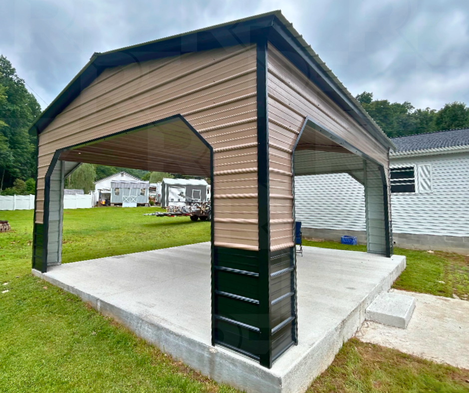 A metal carport with a concrete slab foundation in a backyard, next to a white house with vinyl siding. The carport has a peaked roof and open sides.