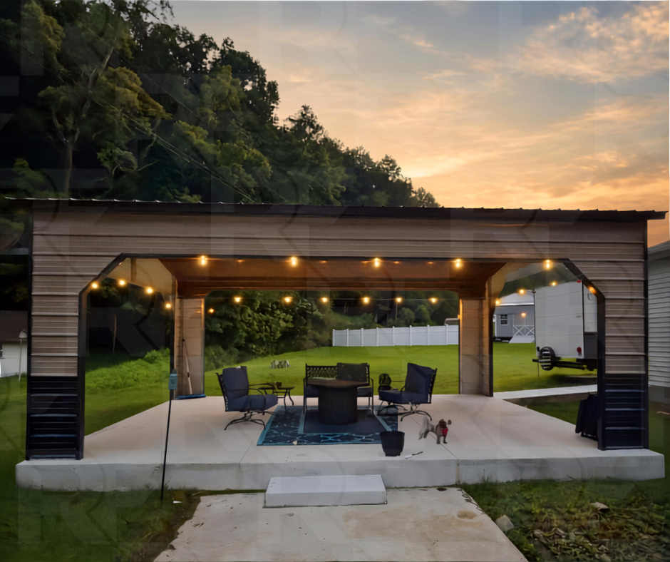 A backyard patio with string lights, outdoor chairs, and a small dog at sunset, with a grassy yard, a white privacy fence, and a hill with trees in the background.