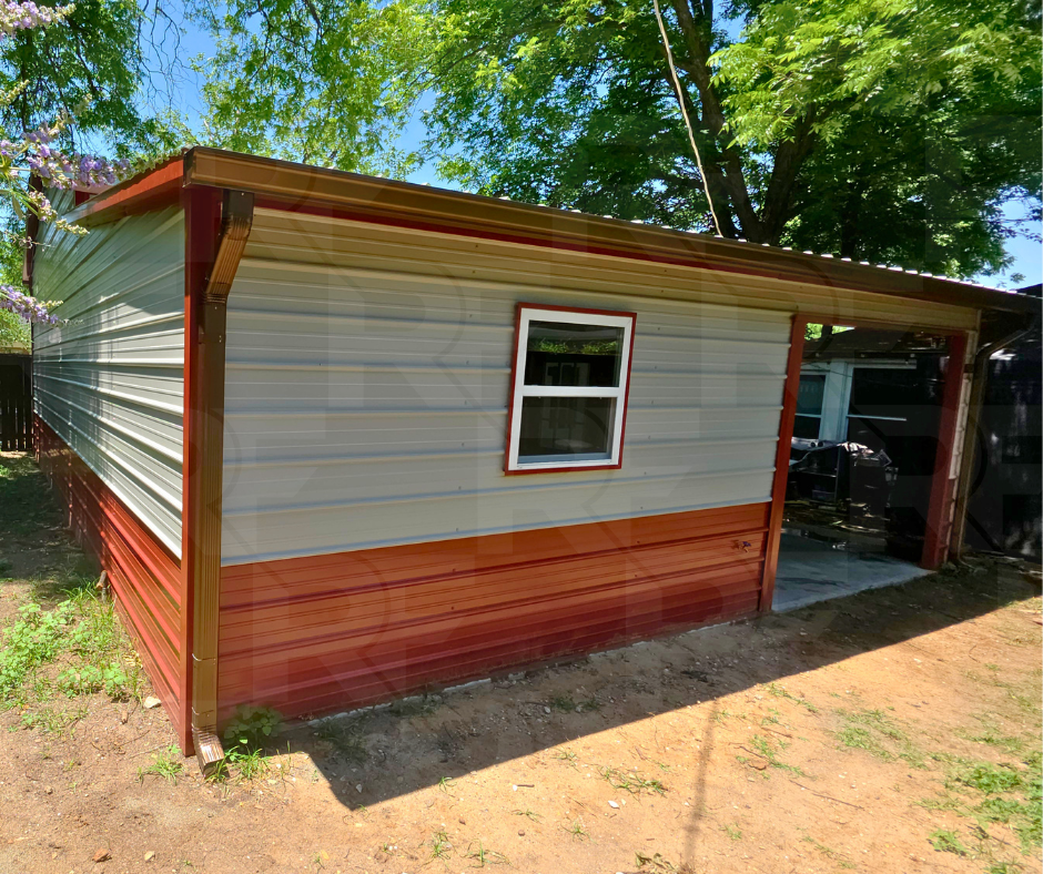 A small metal shed with red and beige siding, a single window, and a small concrete porch, located outdoors with trees and a dirt ground around it.