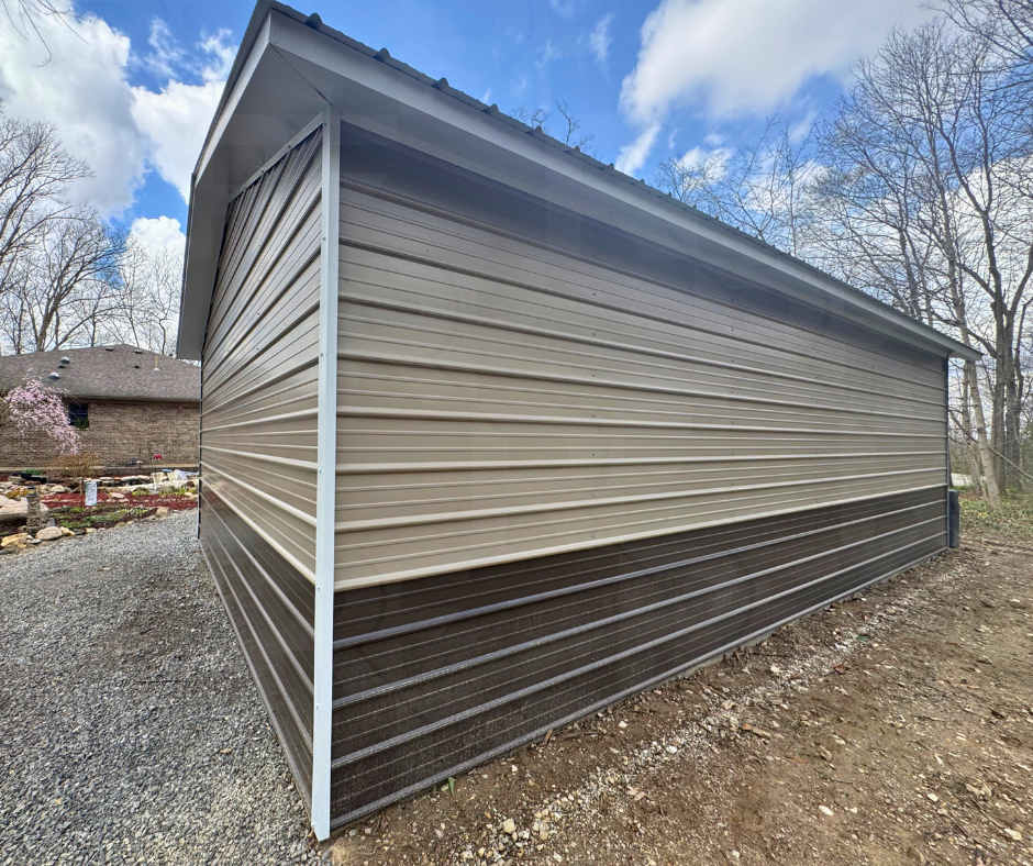 A large metal storage shed with a two-tone color scheme, beige on the upper portion and dark brown on the lower part, situated on a gravel surface in a backyard with trees and a brick house in the background under a partly cloudy sky.