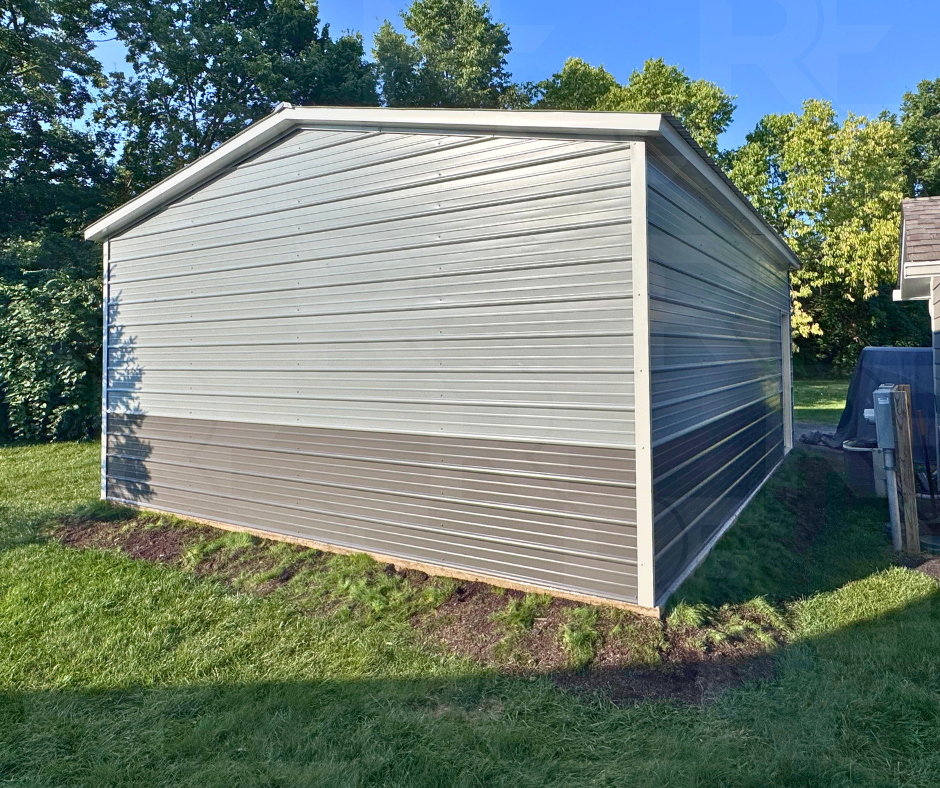 Angled view of gray 20x25 metal garage with residential entry door and white trim