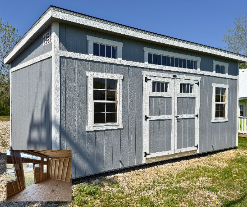 Gray single slope wood shed, white trim and transom windows on front