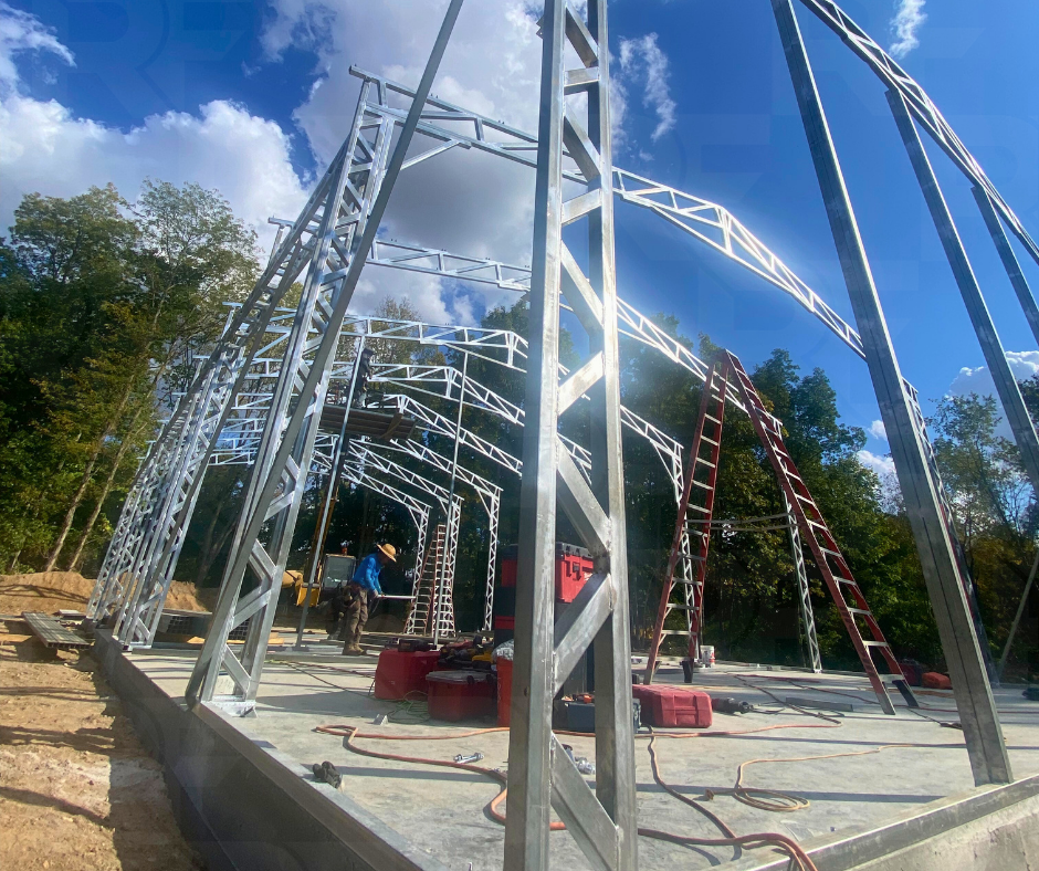 Large steel building with three 14×14 equipment openings and vertical siding.