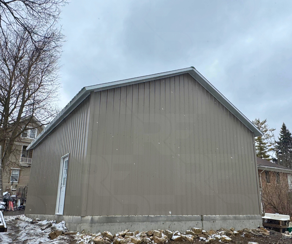 Custom steel garage featuring one-foot overhangs and residential styling.