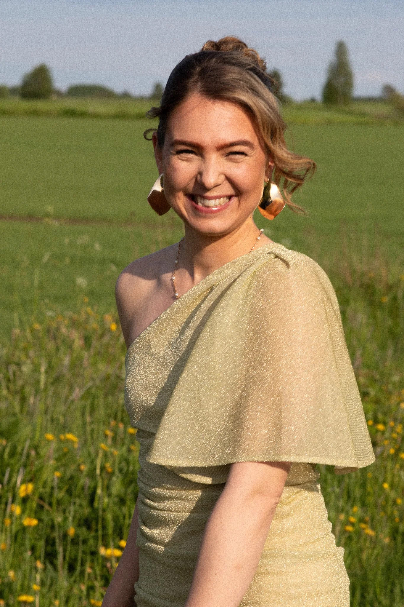 Hymyilevä nainen pellolla – henkilöbrändikuvaus lämpimässä luonnonvalossa ja rennossa kesäisessä tunnelmassa