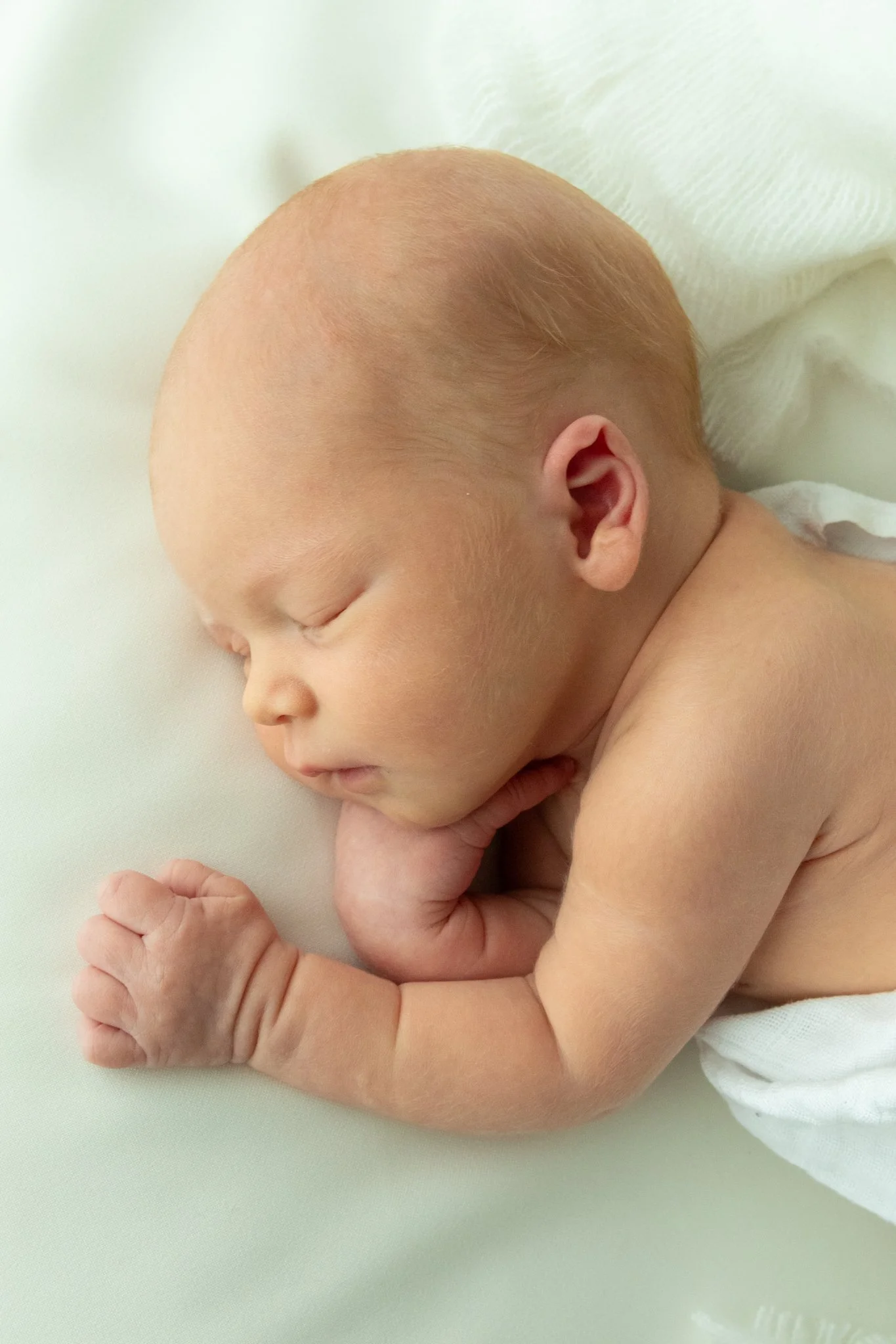 Vastasyntynyt vauva nukkuu rauhallisesti – minimalistinen newborn-kuvaus vaaleassa ja harmonisessa sävymaailmassa