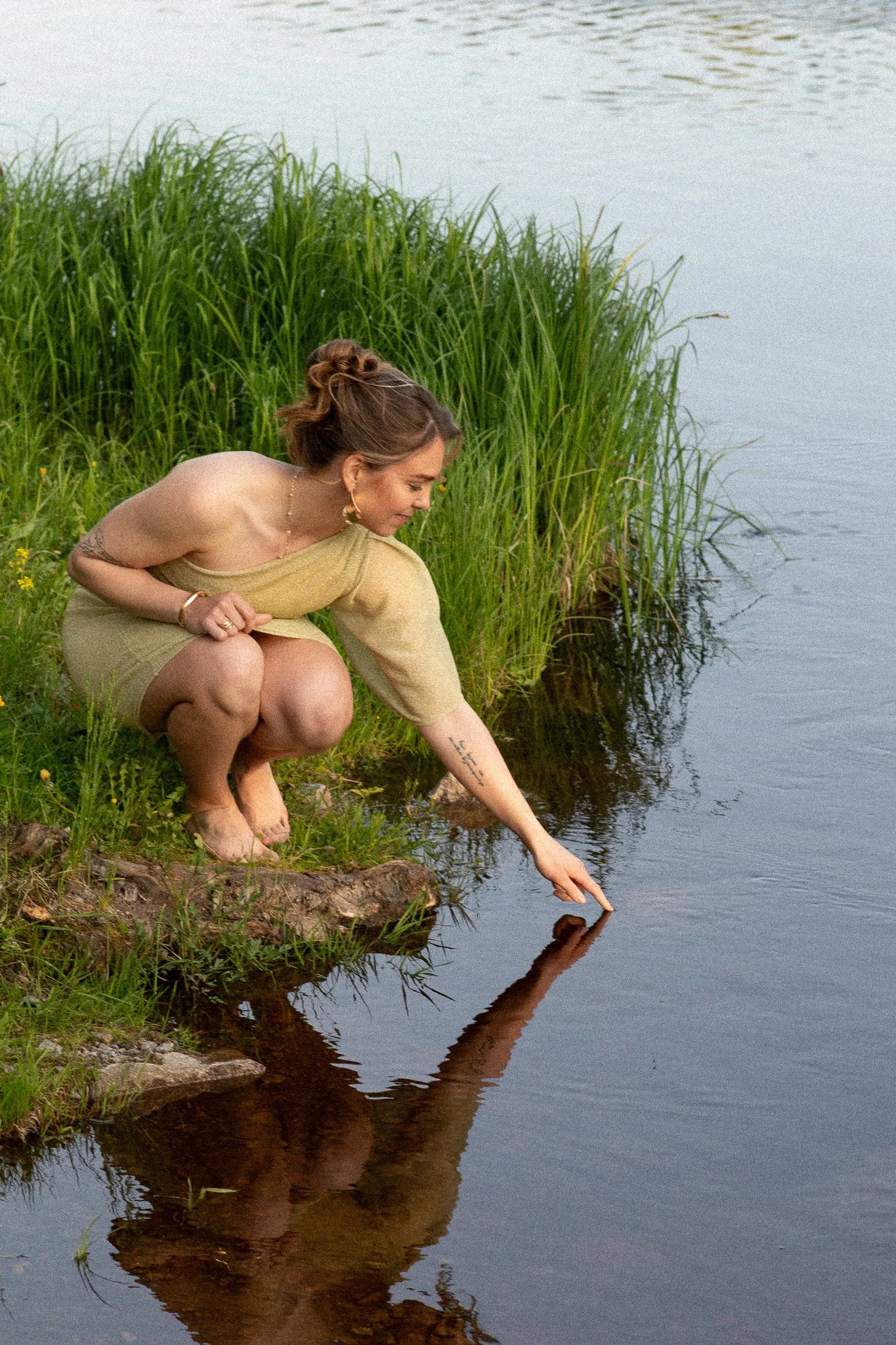 Nainen veden äärellä luonnossa – henkilöbrändikuvaus rauhallisessa ja luonnollisessa ympäristössä pehmeässä valossa