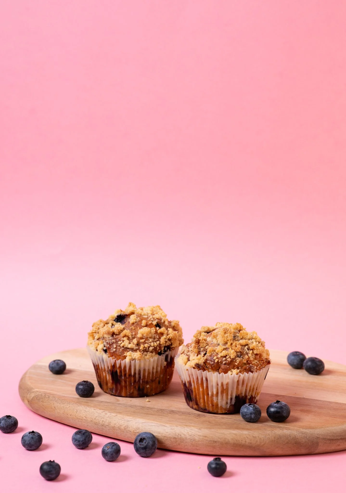 Mustikkamuffinit minimalistisessa asetelmassa – brändiä vahvistava tuotekuvaus vaalealla taustalla