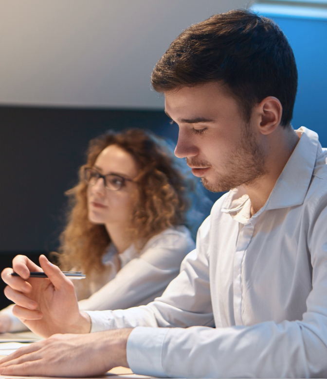 A person looking at their notes while holding a pen