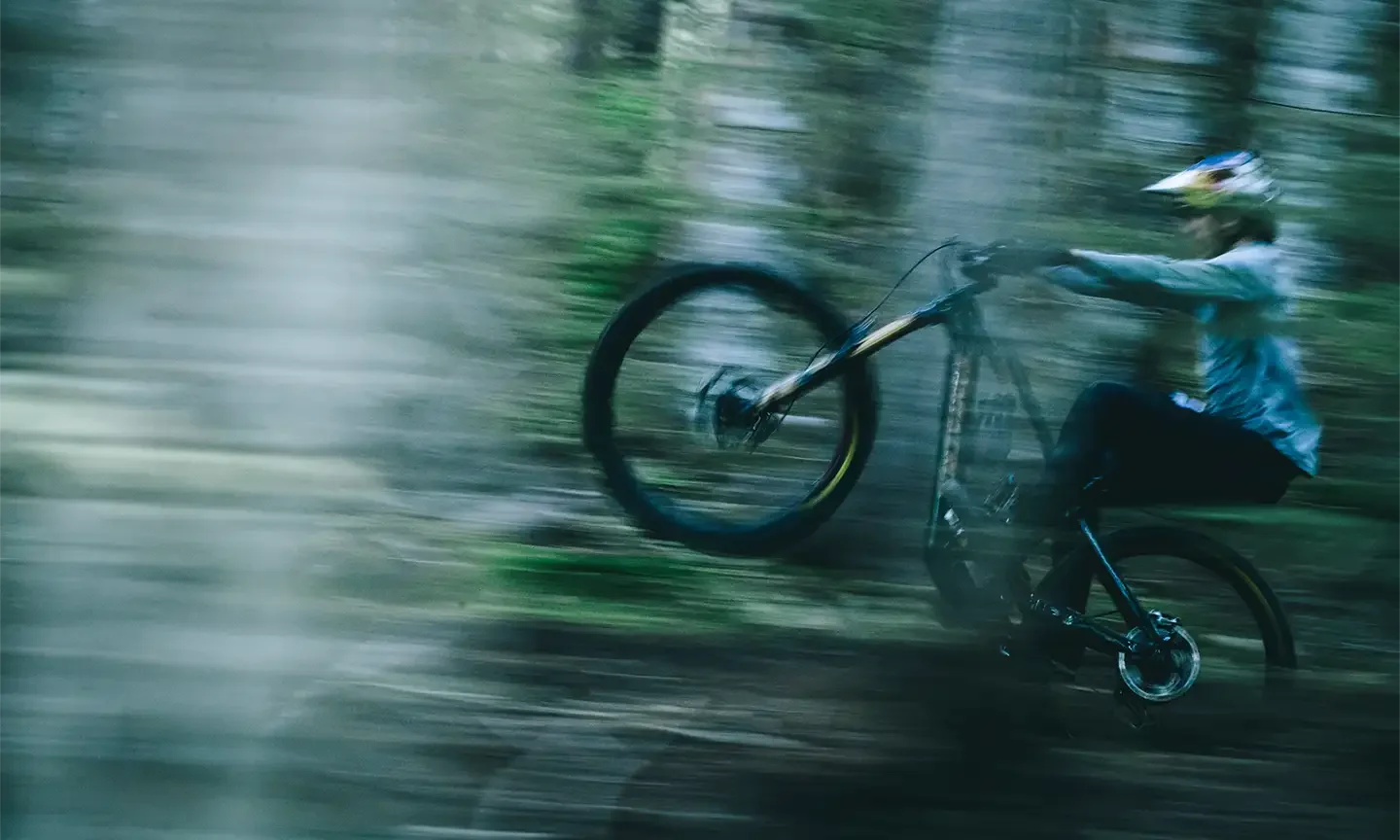 Fahrradfahrer macht ein Wheelie im Wald auf einem Santa Cruz Vala