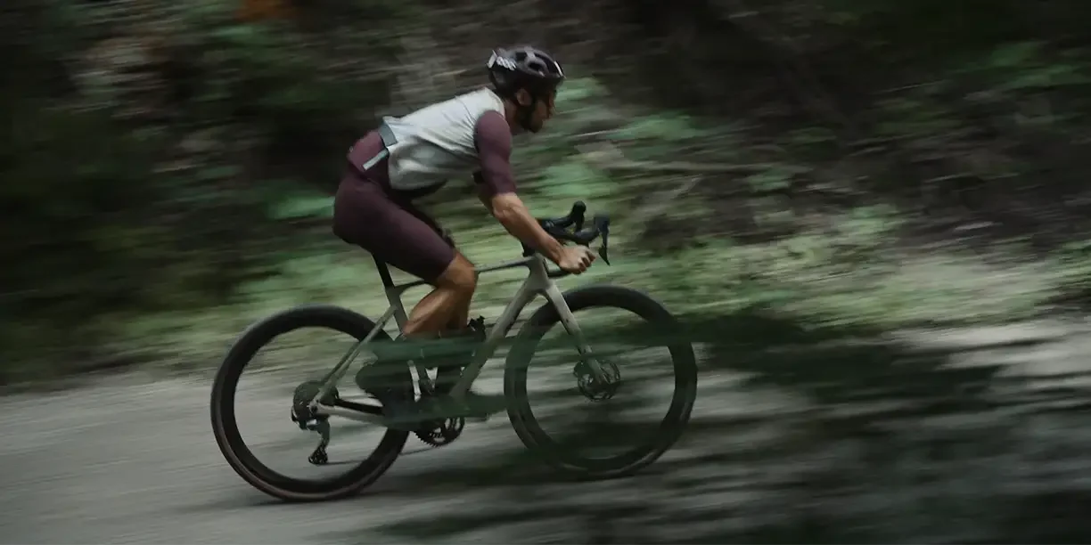 Velofahrer fährt auf einem Gravelbike der Marke Awson durch den Wald