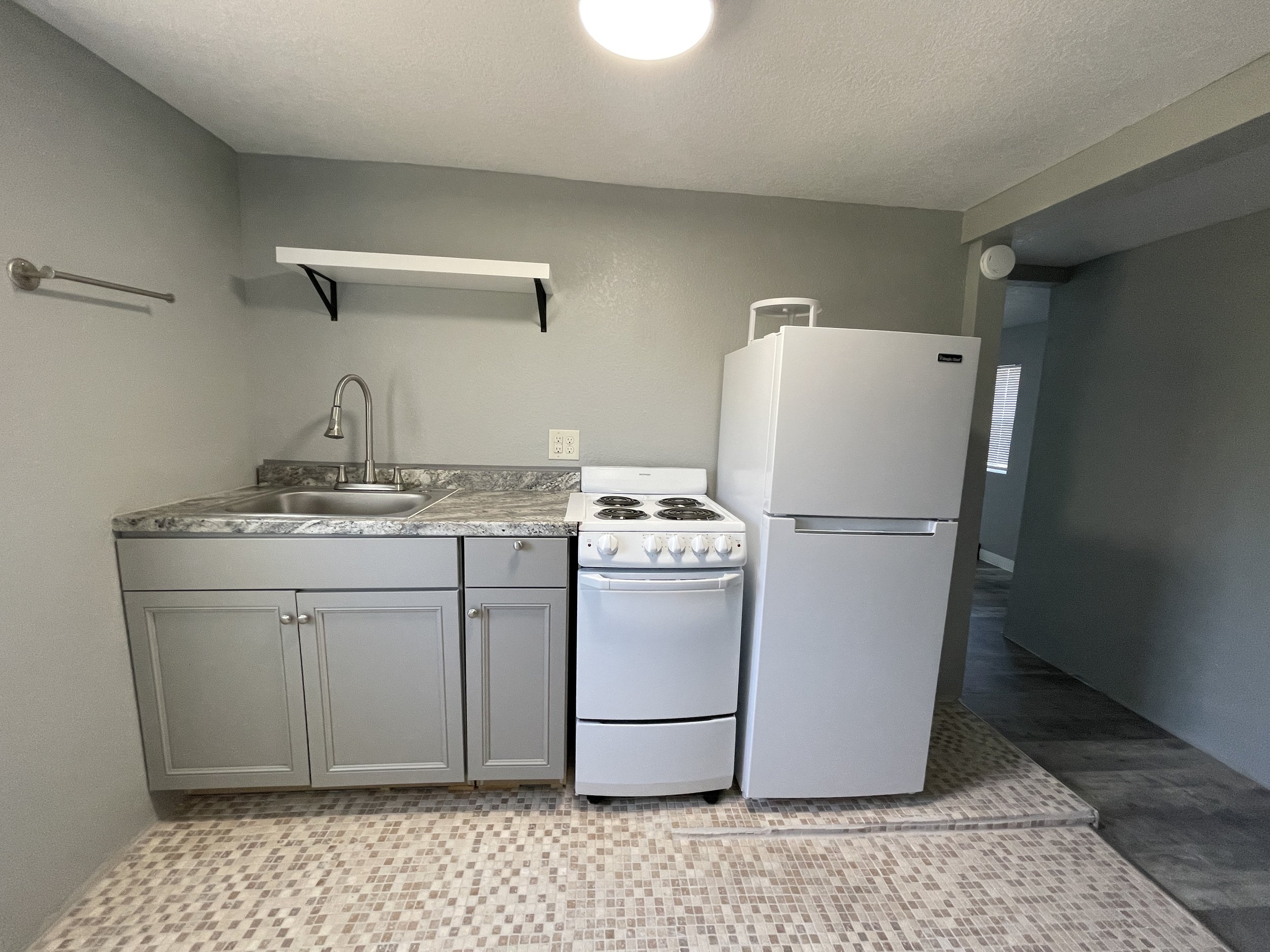 Close-up of a studio kitchenette featuring a clean sink and dedicated counter space for food preparation and small appliances.