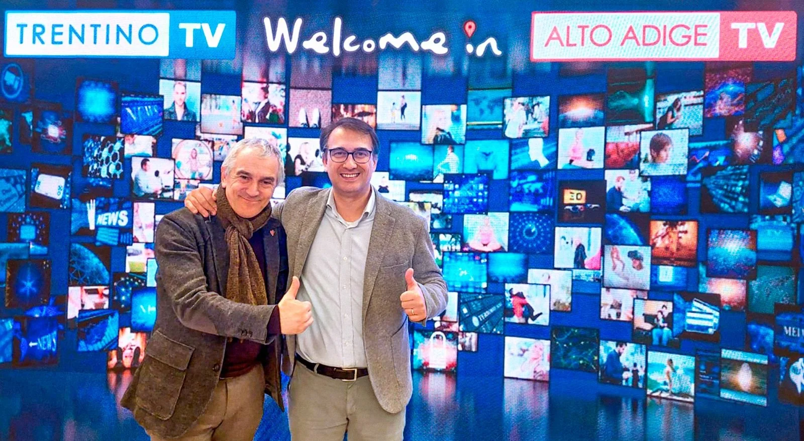 Walter Nicoletti, giornalista e conduttore di BuonAgricoltura e Paolo Holneider regista e produttore della trasmissione sorridono in una foto con lo sfondo di trentino tv e Alto Adige TV