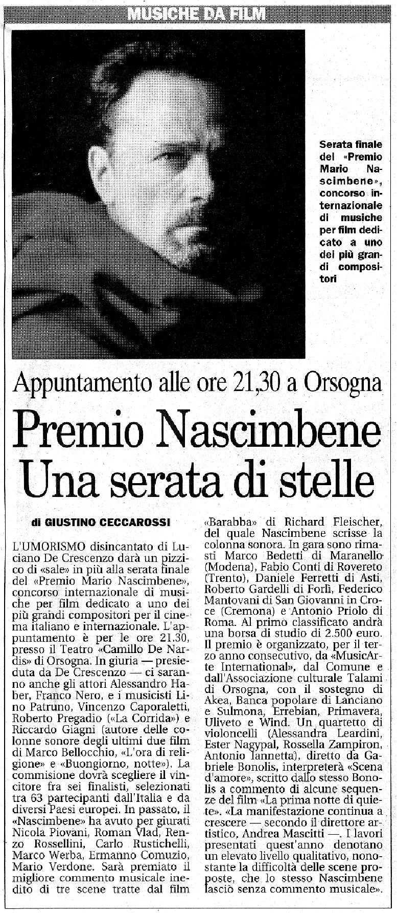 Fotografia in bianco e nero di un uomo con capelli e barba corti, che guarda a sinistra.