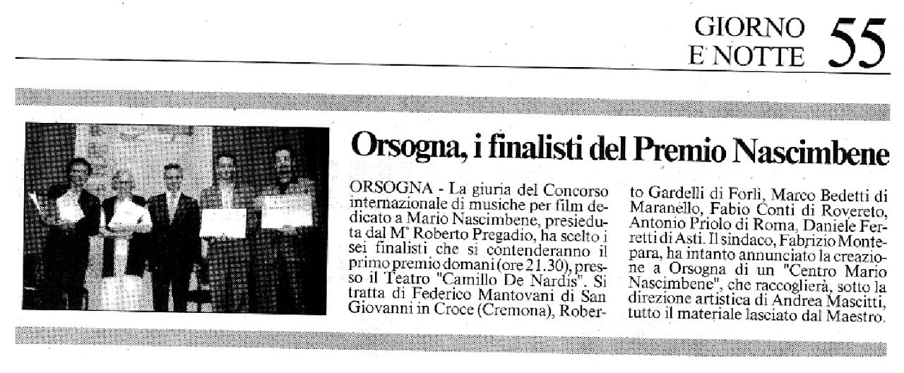 Foto in bianco e nero di sei persone che tengono dei premi o documenti, posizionate in fila, sfondo di un teatro o sala conferenze.