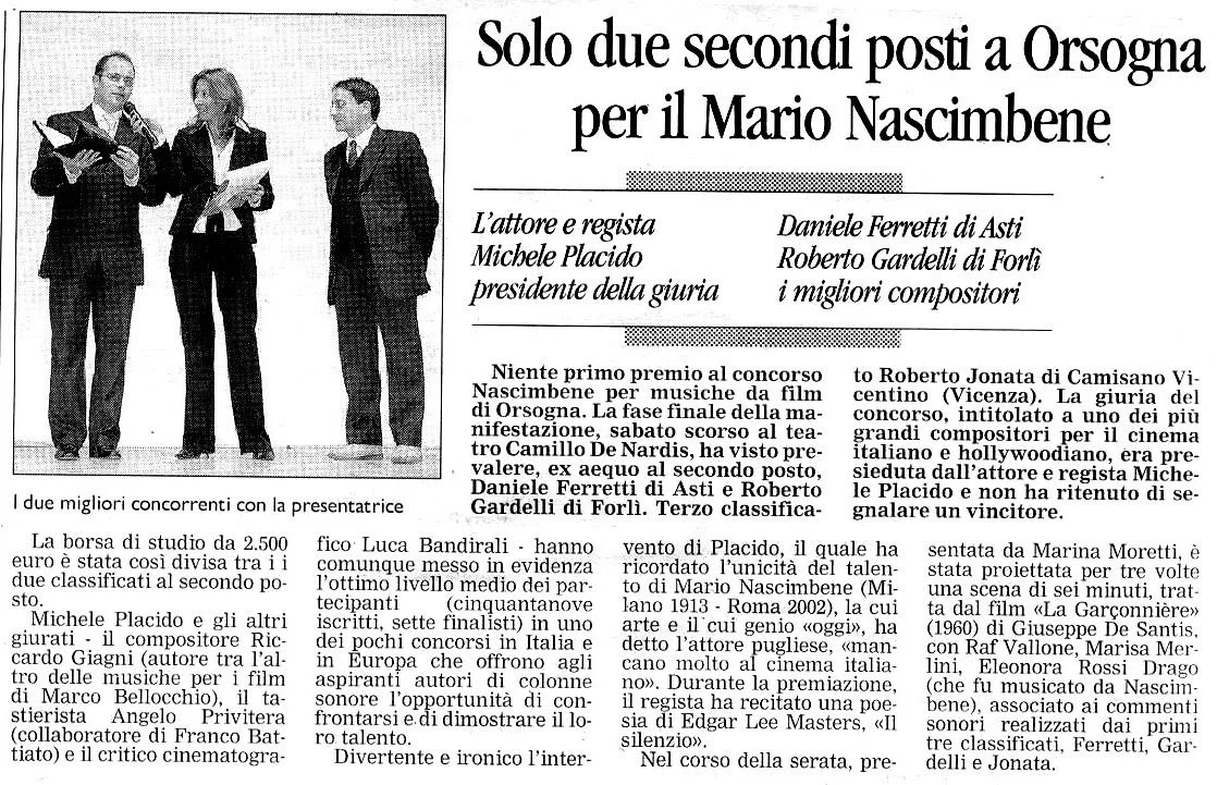 Una scena teatrale con tre persone sul palco, due uomini e una donna, che sembrano recitare o parlare, in un contesto di premiazione o evento culturale.