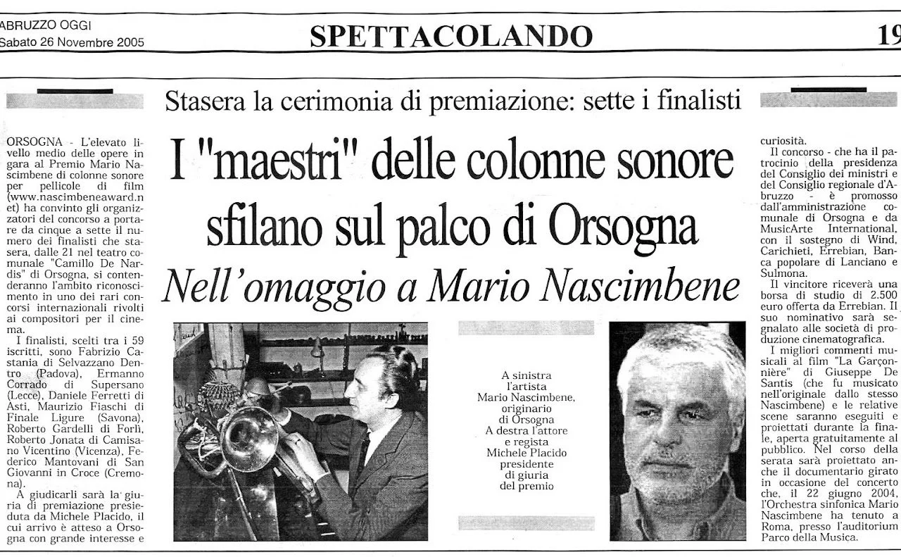 Artista Mario Nascimbene che tiene una camera di scena in mano a Orsogna, affiancato da Michele Placido durante la premiazione.