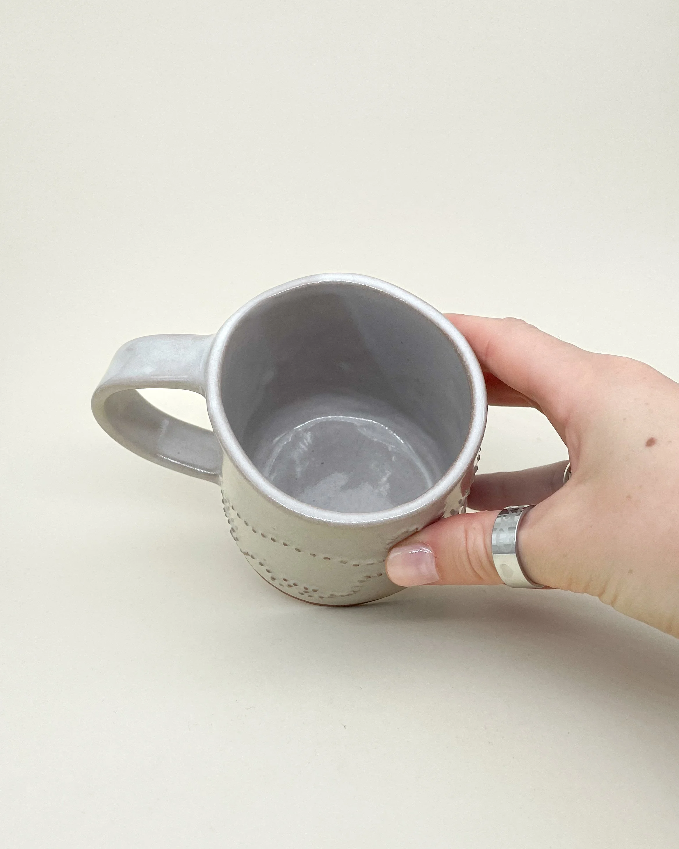 Hand holding, Ceramic Mug, Zebidee #2, white gloss glaze, embossed dot detail, Decoration saves.jpg