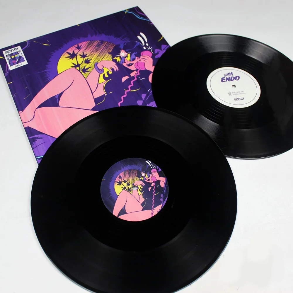 Two vinyl records and a colorful album cover featuring an illustration of a woman talking on the phone, set against a background of a yellow moon and purple sky with leaves.
