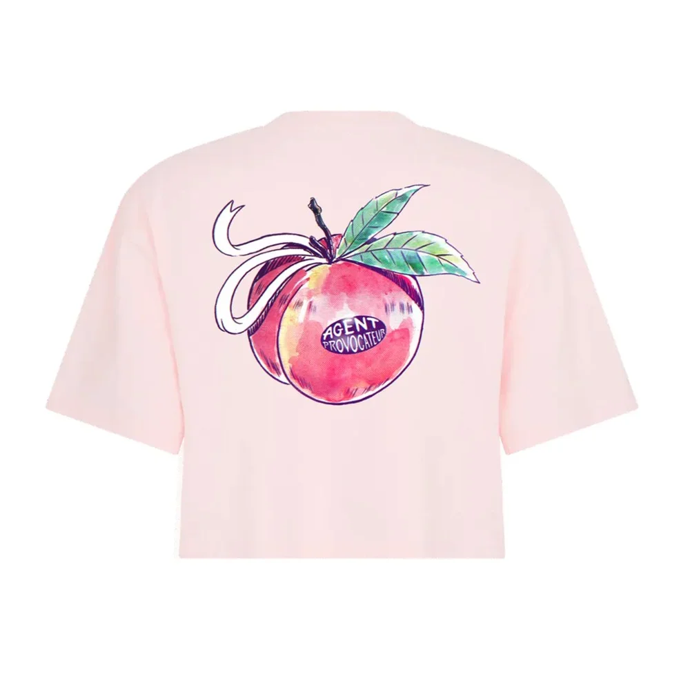 Light pink T-shirt with a large illustration of a peach, leaves, and cherries, with a label that says "Agent Provocateur."