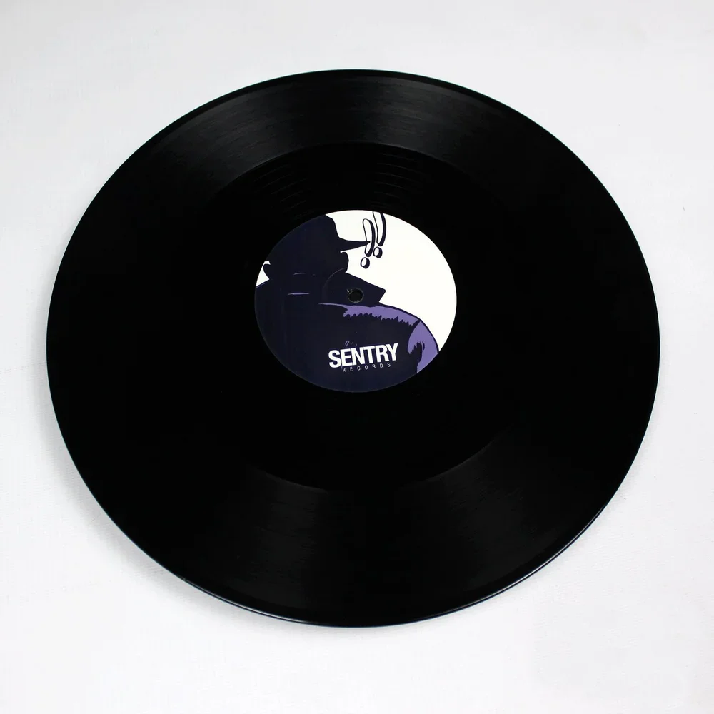 A black vinyl record with a label showing a silhouette of a person with a hat and glasses, and the text 'SENTRY RECORDS'.