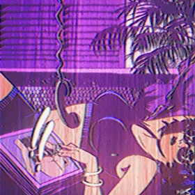 A woman with dark hair is talking on a rotary phone while lying on her stomach at a desk with a vintage telephone and a pen.